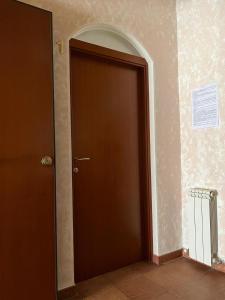 a brown door in a room with a wall at Vacanze Deaf in Rome