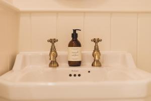 ein Waschbecken mit einer Flasche Wein drauf in der Unterkunft Buckingham Mews Pebble Cottage 3 in Broadstairs + 16 Fotos