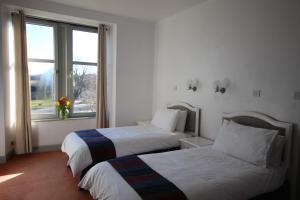 a hotel room with two beds and a window at Hotel Square in Tomintoul
