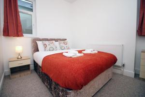 a bedroom with a bed with two towels on it at Camelot House by Tŷ SA in Newport