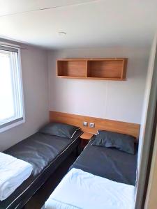 ein kleines Zimmer mit 2 Betten und einem Fenster in der Unterkunft CAMPING SIBLU - LA RESERVE **** - Mobile Home - 3 ch. - (8pers) in Gastes