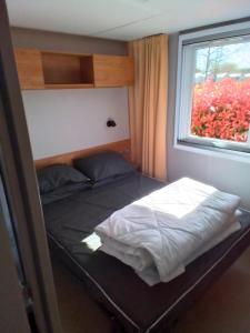 a small bed in a room with a window at CAMPING SIBLU - LA RESERVE **** - Mobile Home - 3 ch. - (8pers) in Gastes