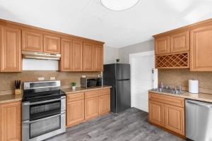 a kitchen with wooden cabinets and stainless steel appliances at 1 Mile to Birmingham CrossPlex & Near Legion Field in Birmingham