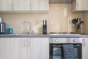 a kitchen with a sink and a stove at Modern 1 bedroom - Church View 4 by Tŷ SA in Newport