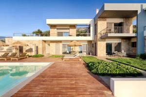 a villa with a swimming pool and a house at Euphoria Suites in Avía