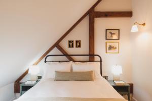 ein Schlafzimmer mit einem weißen Bett mit zwei Lampen in der Unterkunft Buckingham Mews Pebble Cottage 3 in Broadstairs