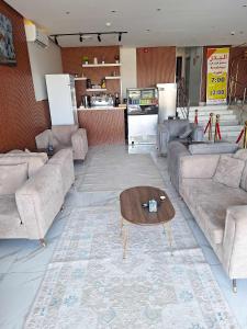 Sala de estar con sofás y mesa de centro en البدر للشقق المخدومة, en Sīdī Ḩamzah