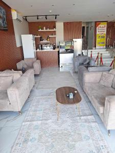 Una sala de estar con sofás y una mesa de café. en البدر للشقق المخدومة, en Sīdī Ḩamzah