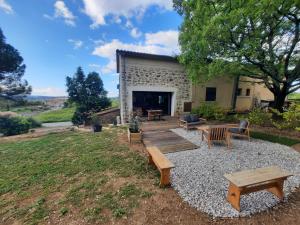 a backyard with a wooden deck and benches at La Figueraie in Vinezac