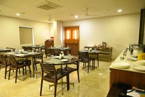 a restaurant with tables and chairs in a room at HOTEL ROYAL PARK in Nellore
