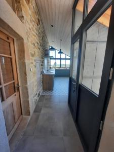 a hallway with a door leading to a kitchen at La Figueraie in Vinezac