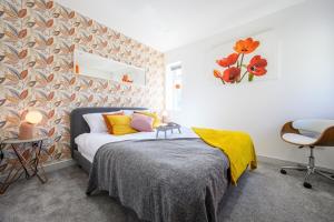 una camera da letto con un letto con cuscini gialli e arancioni di Central Location - Riverside Gardens #2 by Tŷ SA a Cardiff