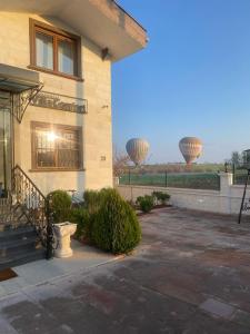 a building with two hot air balloons in the background at Cappadocia Villa Comfort in Nevsehir