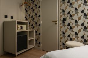 a room with a bed and a tv and a door at Arc Elysées in Paris