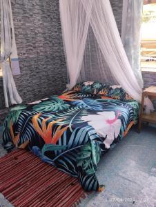 a bedroom with a bed with a canopy at CHAMBRE CHEZ TAPUHERE LODGE in Fare