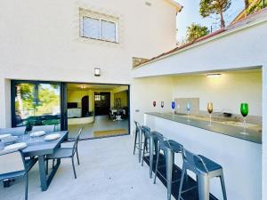 eine Terrasse mit Tischen und Stühlen sowie eine Bar in der Unterkunft Cardina CostaBravaSi in Sant Feliu de Guixols