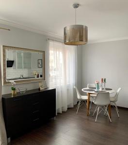 a kitchen and dining room with a table and chairs at Apartament Gdynia Park 1 in Gdynia