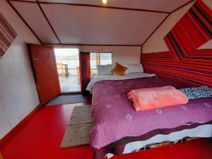 プーノにあるUros Titicaca UMA lodgeの窓付きの部屋にベッド付きのベッドルーム1室があります。