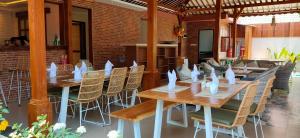 a dining room with tables and chairs with napkins on them at Taman Amertha Villas by Maha Bali in Seminyak