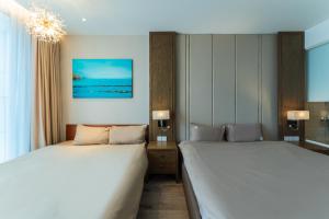 a bedroom with two beds and a chandelier at Panorama Superview Nha Trang Apartment in Nha Trang