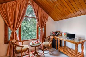 西姆拉的住宿－Alaya Stays Meridian Oak 5BHK Villa in Shimla，一个带书桌和窗户的家庭办公室