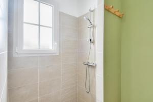 a bathroom with a shower with a window at Maison pour 4 - jardin - 600m de la plage in Barbâtre +8 photos