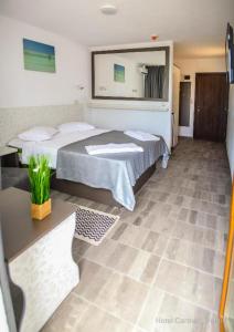 ein Hotelzimmer mit 2 Betten und einem Spiegel in der Unterkunft Hotel Carmen in Venus