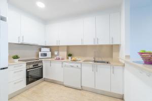 エンプリアブラバにあるApart-rent Apartment Blaucel 0086の白いキャビネットとシンク付きのキッチン