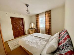 a bedroom with a white bed and a window at Gudauri Deka House, Balcony & Mountain Views in Gudauri