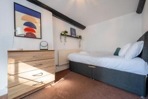 a bedroom with a large bed and a dresser at Chapel Lodge by Tŷ SA in Newport
