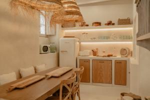 cocina con mesa de madera y nevera en EntreArcos Casa Eco-Boutique en Vejer de la Frontera