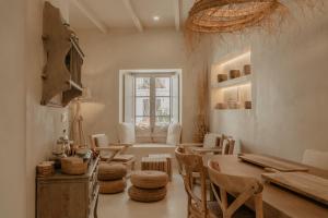 une chambre avec une table, des chaises et une fenêtre dans l'établissement EntreArcos Casa Eco-Boutique, à Vejer de la Frontera