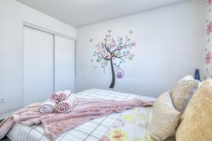 a bedroom with a bed with a tree on the wall at Premier Villas in Ajax