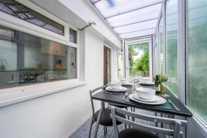 a dining room with a table and chairs and a window at Chapel Lodge by Tŷ SA in Newport