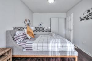 - une chambre avec un lit et un canapé gris dans l'établissement Premier Villas, à Ajax