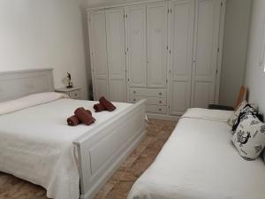 twee bedden in een slaapkamer met witte kasten bij CASA ZENOBIO in Pabillonis