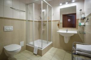 a bathroom with a shower and a toilet and a sink at Hotel Jaworzyna Krynicka in Krynica Zdrój