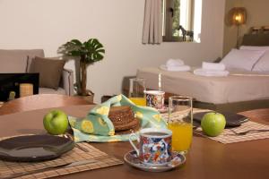 a table with a breakfast of bread and orange juice at Lithorama Residence Mani - Second Floor in Koúmani