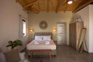 a bedroom with a large white bed and a table at Lithorama Residence Mani - Second Floor in Koúmani