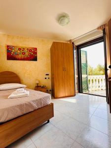 a bedroom with a bed and a large sliding glass door at Il Corbezzolo in Ripatransone