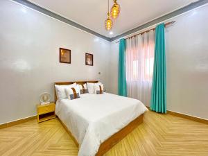 坎帕拉的住宿－Edenhomes，一间卧室配有一张带蓝色窗帘的大床