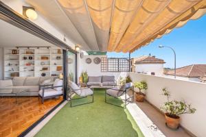 a patio with a couch and chairs on a balcony at Mar de fondo en Pedregalejo in Málaga