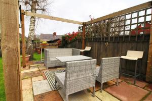 d'une terrasse avec des chaises, une table et une clôture. dans l'établissement Nessa’s Nook by Tŷ SA - Newport, à Newport