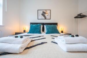 a bedroom with a large bed with blue pillows at Clayton Street by Tŷ SA in Newport