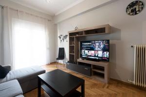 uma sala de estar com um sofá e uma televisão de ecrã plano em Central apartment 3' to Metaksourgio metro station em Atenas
