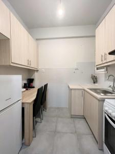 uma cozinha com armários brancos e uma mesa e cadeiras em Central apartment 3' to Metaksourgio metro station em Atenas