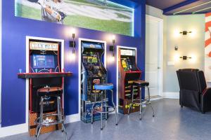 une chambre avec deux machines de jeux vidéo et deux tabourets dans l'établissement Top Villas - Encore Resort 1549, à Orlando