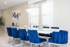 une salle à manger avec des chaises bleues et une table blanche dans l'établissement Top Villas - Encore Resort 1549, à Orlando