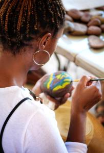 Una mujer está pintando una rosquilla en una mesa. en Valor Wellness Retreat en Windhoek