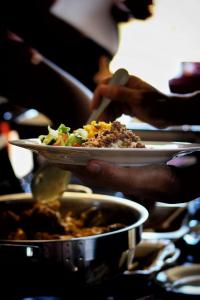 una persona sosteniendo un plato de comida en una mesa en Valor Wellness Retreat en Windhoek